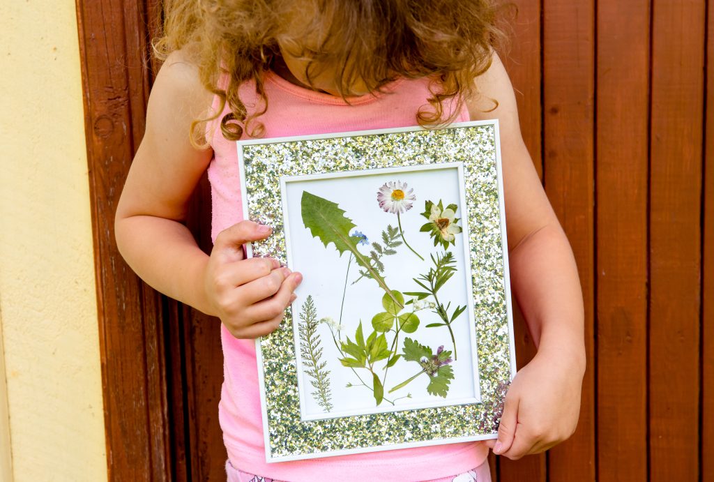 Kind mit Trockenblumen-Bild